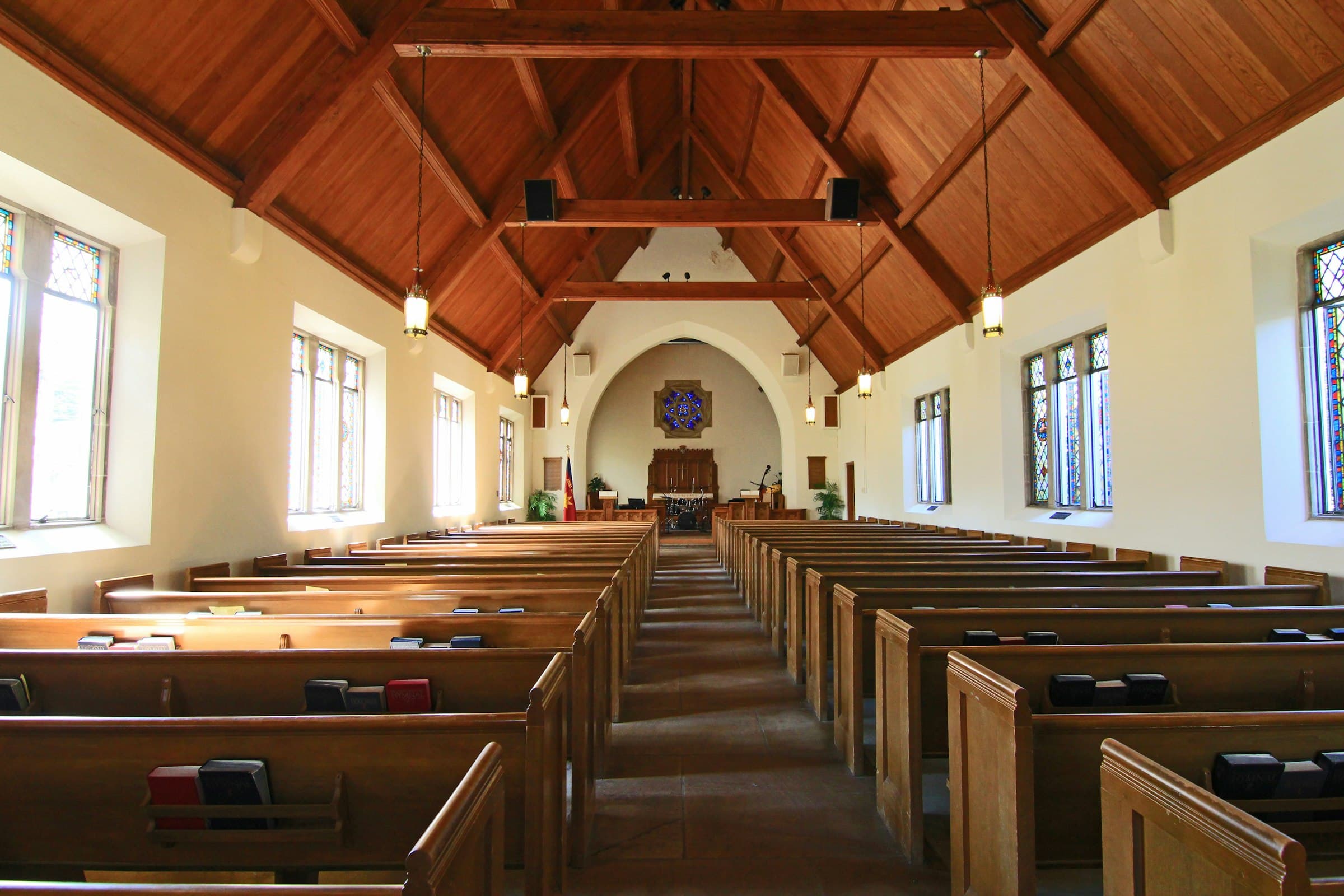 A bright, empty church nave with wooden pews